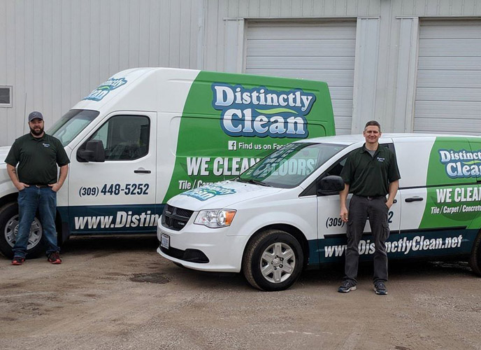 Distinctly Clean employees standing in front of company vehicles